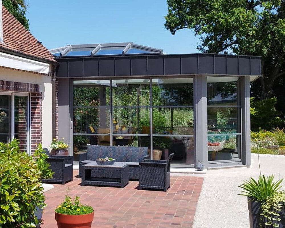 Un patio avec un grand mur en verre et une table de patio élégante