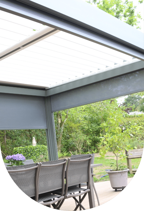 Un patio avec une table et des chaises sous un auvent, offrant un espace de détente en plein air