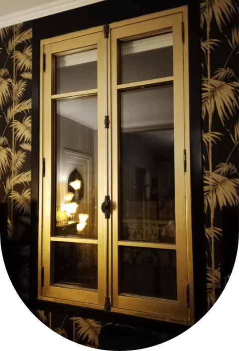 Une fenêtre dorée avec un papier peint noir et blanc en arrière plan