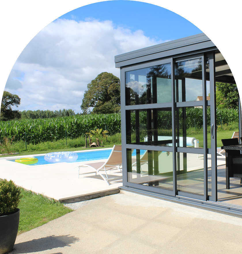 Une porte en verre s'ouvre sur un patio avec une piscine