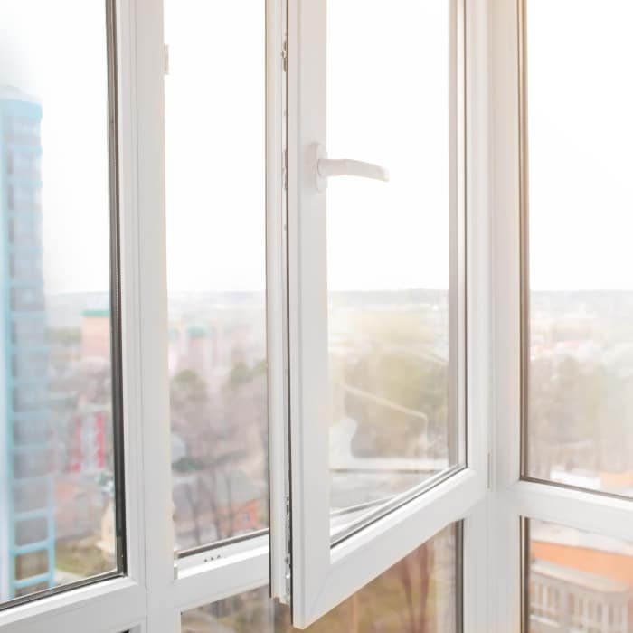 Fenêtre PVC avec vue sur une ville animée, montrant des bâtiments et des rues en contrebas